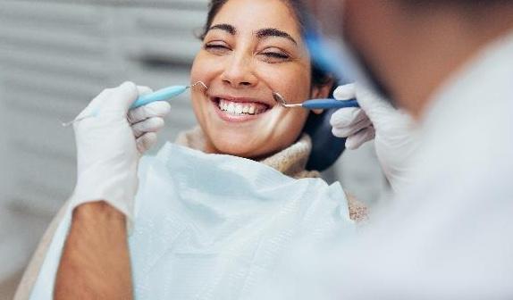 gum disease treatment dedham | woman at dentist