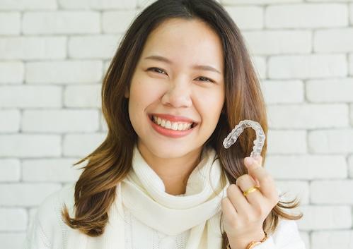 invisalign dentist dedham | woman holding aligner