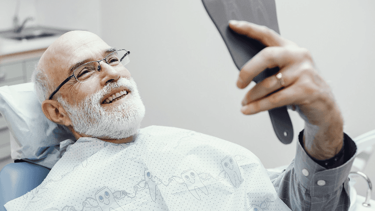 tooth replacement near me | man at dentist in dedham